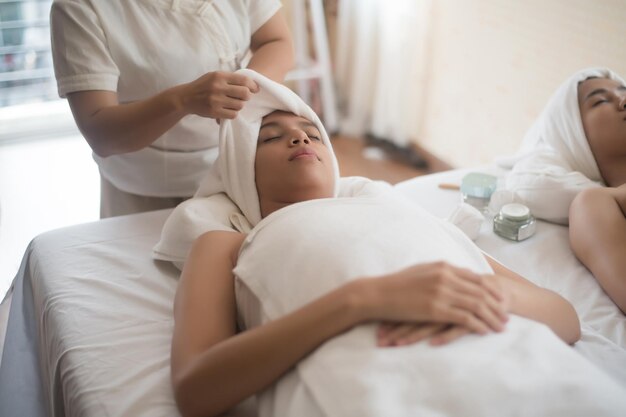 Foto midsection der masseurin, die eine frau im spa massiert