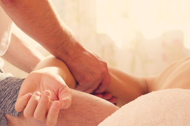 Midsection des Therapeuten, der eine Frau im Spa massiert