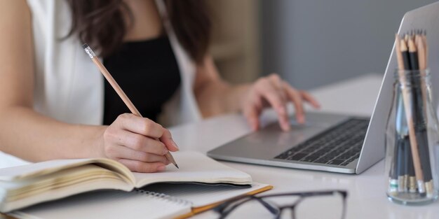 Midsection einer Frau, die ein Smartphone auf dem Tisch benutzt