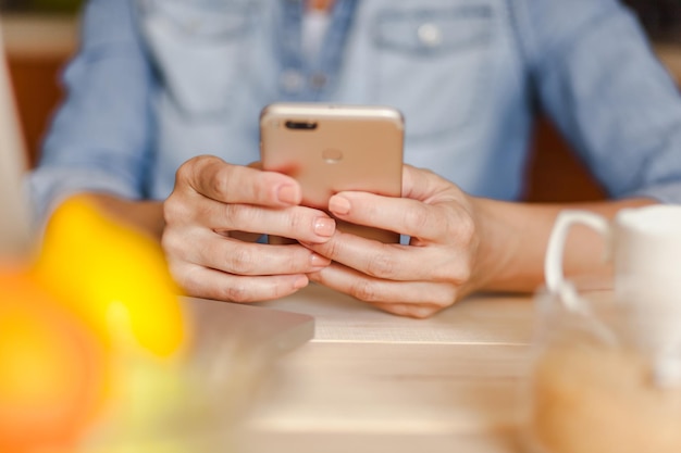 Midsection einer Geschäftsfrau, die am Tisch in einem Café mit dem Telefon spricht