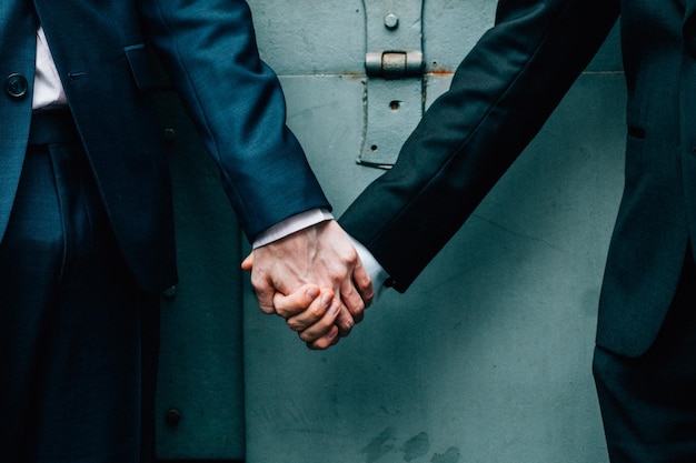 Midsection eines homosexuellen Paares, das sich während der Hochzeit an der Tür hält