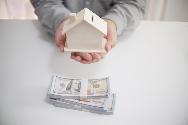 Midsection eines Immobilienmaklers, der ein Modellhaus am Schreibtisch im Büro hält