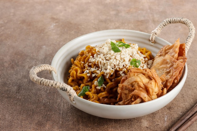 Mie Goreng ala Mie Gacoan es una cobertura casera de fideos fritos con pollo desmenuzado y bola de masa frita.