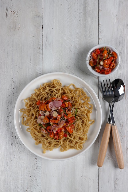 Mie Goreng Sambal Matah oder gebratene Instan-Nudeln, serviert mit Sambal Matah