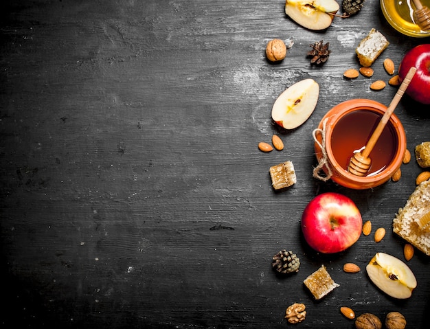 Miel en bote con rodajas de manzanas maduras y nueces.