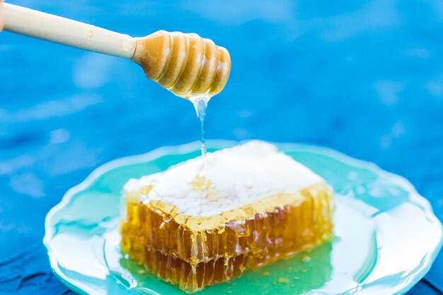 Miel con cucharón de miel de madera y panales, close-up
