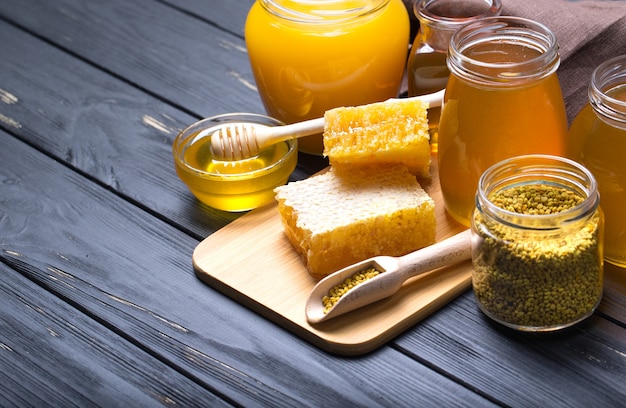 Miel con cucharón de miel de madera sobre mesa de madera