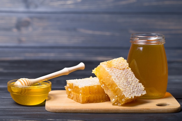 Miel con cucharón de miel de madera sobre mesa de madera