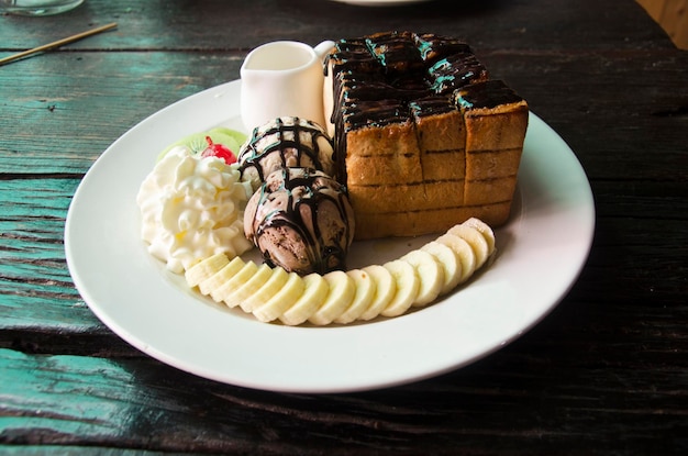 Miel decorada y lava de chocolate en tostadas con helado de vainilla y plátano y crema batida en el restaurante Tailandia