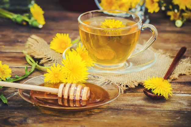 Miel de diente de león y una taza de té. Enfoque selectivo