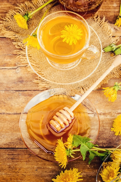 Miel de diente de león y una taza de té. Enfoque selectivo