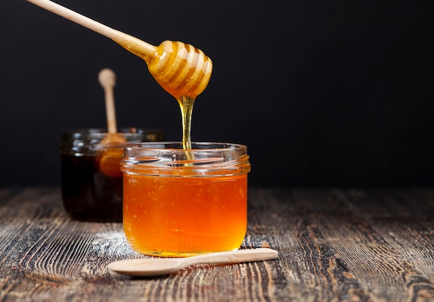 Foto miel dulce espesa y deliciosa actual, un producto alimenticio natural y saludable creado por las abejas, la miel de abeja natural tiene una consistencia viscosa y espesa