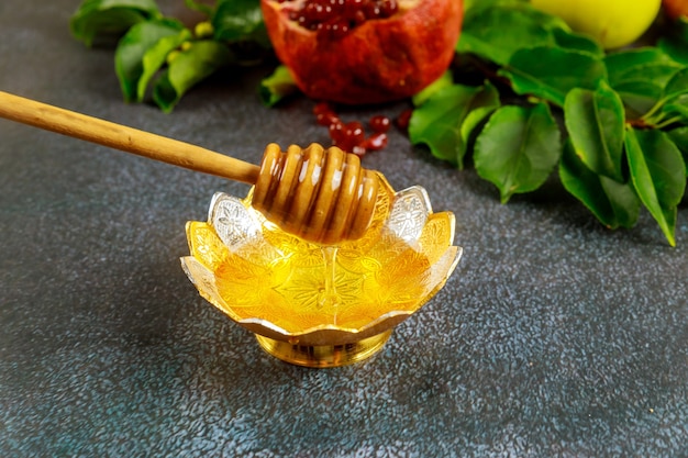 Miel dulce tradicional con palo de madera y frutas para la fiesta judía de Rosh Hashaná.