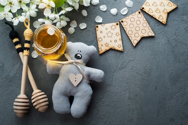 Miel con flores y cucharas de madera.