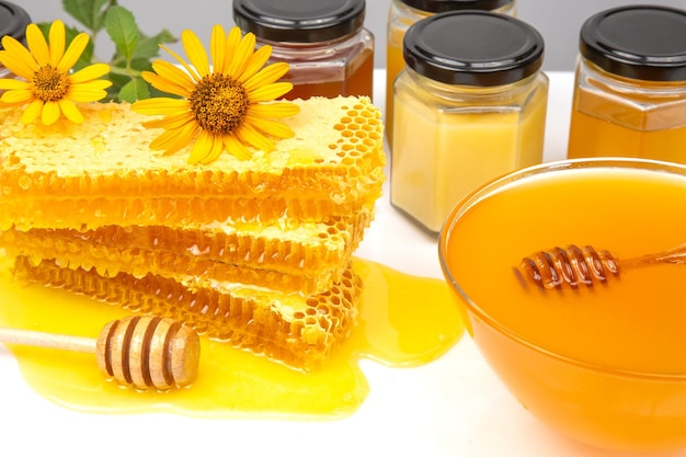Miel de flores frescas en una cuchara de cuenco de madera y alimento vitamínico de panal para la salud y la vida