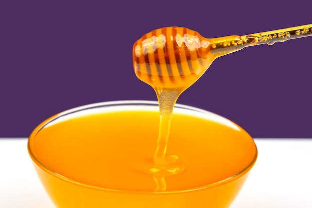 Miel fragante fresca que gotea de una cuchara en un plato. nutrición de vitaminas orgánicas