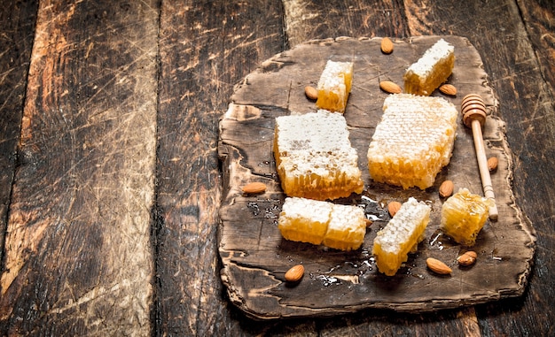 Miel fresca con almendras. Sobre fondo de madera.