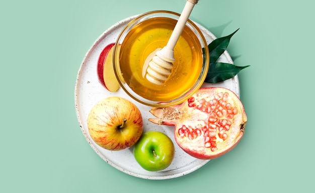 Miel de manzana y granada sobre un fondo verde menta Concepto Año Nuevo judío Rosh Hashaná