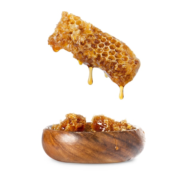Miel en un panal goteando en un plato de madera
