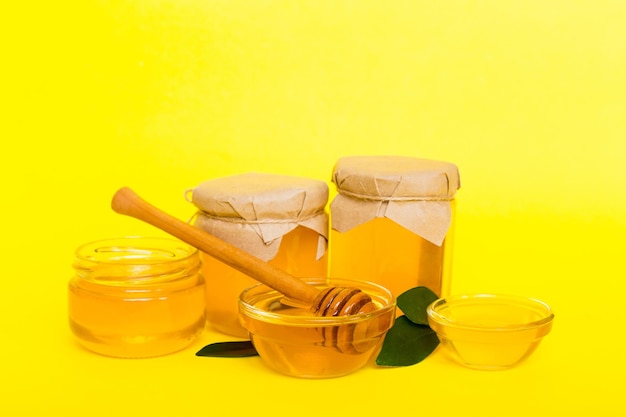Miel en tarro con hojas y cucharón de miel en la vista superior de fondo de color con texto de copia