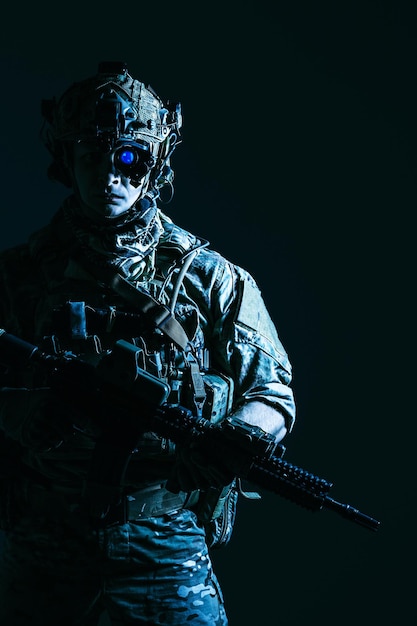 Miembro de élite de los guardabosques del ejército de los EE. UU. En casco de combate y dispositivo de visión nocturna. Foto de estudio, fondo negro oscuro, mirando a cámara, contraste oscuro