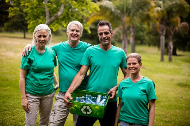 Miembros del equipo de reciclaje de pie en el parque