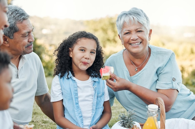 Los miembros de la familia pueden ser tus mejores amigos Fotografía de una anciana alimentando a su nieta con sandía en un picnic