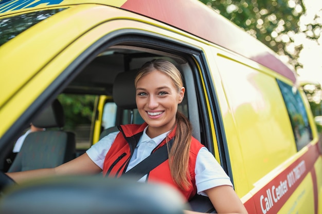 Miembros del personal de ambulancia en su ambulancia Lleva uniforme de ambulancia de paramédicos Está sentada en la ambulancia lista para ir a una llamada