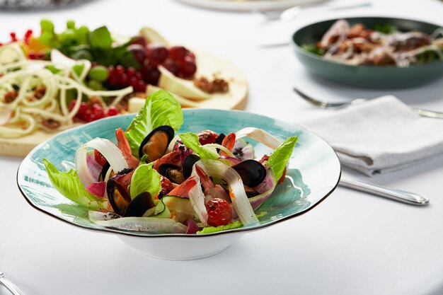 Miesmuscheln in Weißweinsauce, Vongole-Muscheln in einem Teller mit Salat, Meeresfrüchte vom Küchenchef.