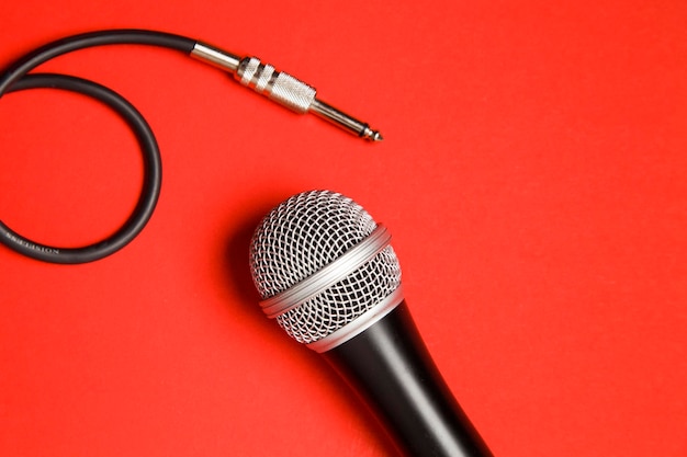 Mikrofon und Blei auf einem leuchtend roten Hintergrund