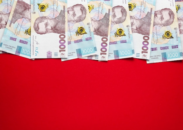 Foto mil notas de hryvnia ucranianas em um fundo vermelho