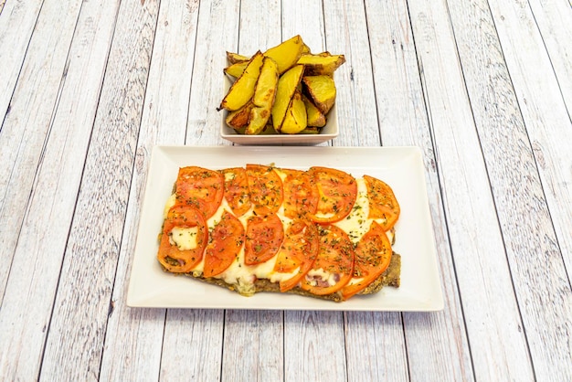 Foto milanesa a la napolitana ist ein typisches gericht der für argentinien und uruguay typischen river plate-gastronomie, das seinen ursprung im einfluss der italienischen einwanderung hat