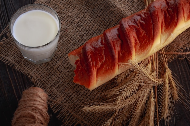 Foto milch in einem glas und weißbrot auf einem holztisch