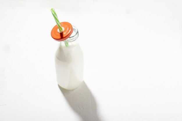 Milch in einer Flasche mit einem Strohhalm auf weißem Hintergrund Pflanzliche Milch oder Joghurt