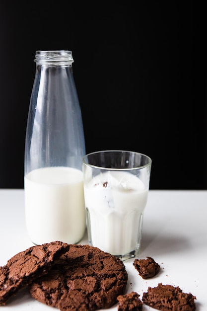 Milch in Glas mit Schokoladenkeksen gießen