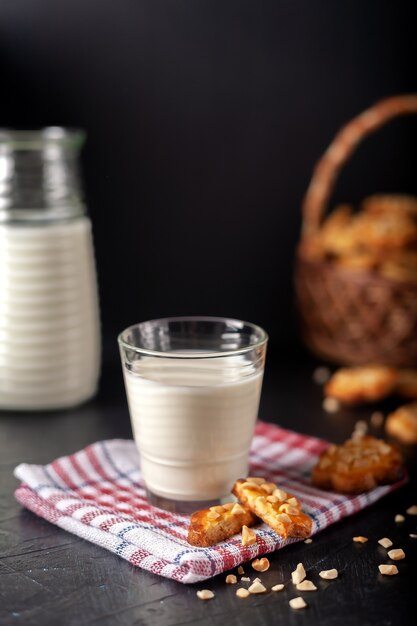 Milch mit frisch gebackenen hausgemachten Erdnusskeksen an dunkler Wand