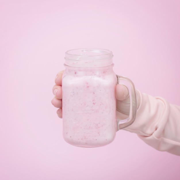 Milch Smoothie mit Beeren auf einer empfindlichen rosa Hintergrundnahaufnahme