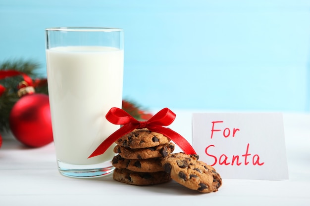 Milch- und Weihnachtsplätzchen für den Weihnachtsmann auf dem Tischweihnachtshintergrund