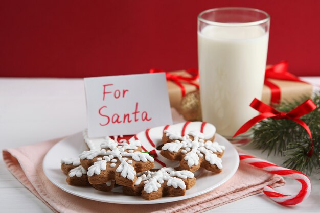 Milch- und Weihnachtsplätzchen für den Weihnachtsmann auf dem Tischweihnachtshintergrund