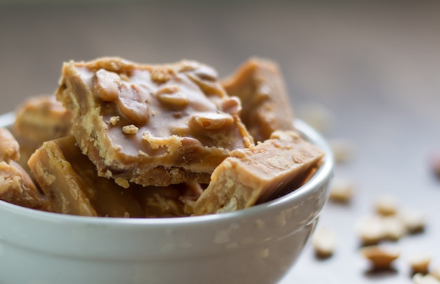 Milchbonbonstücke mit Erdnüssen in der weißen Schüssel.