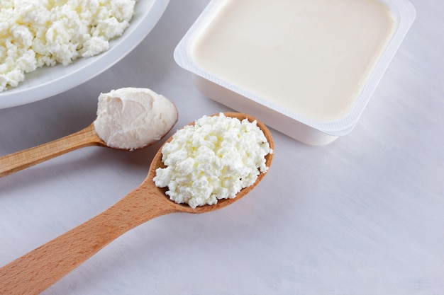 Milchprodukte auf einer weißen Tafel. Hüttenkäse, Sahne und Weichkäse auf weißem Hintergrund