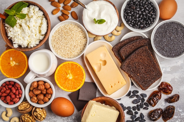 Milchprodukte, Hülsenfrüchte, Eier, Nüsse, Schokolade, Mohn, Sesam, Schokolade. Weißer Hintergrund, Ansicht von oben
