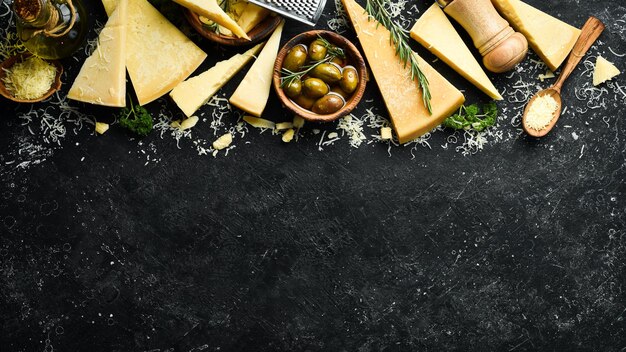 Milchprodukte Parmesan-Käse Oliven und Snacks auf einem Steintisch Draufsicht Auf einem konkreten Hintergrund