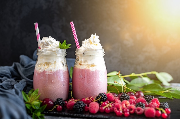 Milchshake-Gläser mit Preiselbeeren, Erdbeeren und Blaubeeren