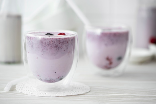 Milchshake mit gefrorenen Beeren in Gläsern