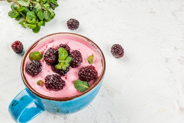 Milchshake oder gefrorener Beerenjoghurt in einer Tasse