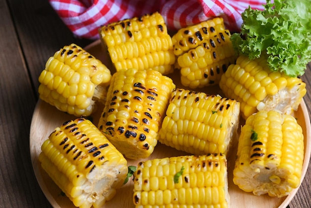 Milho doce cozido no fundo do prato comida de milho doce com salada vegetal alface espigas de milho maduro milho doce grelhado para comida vegan jantar ou lanche