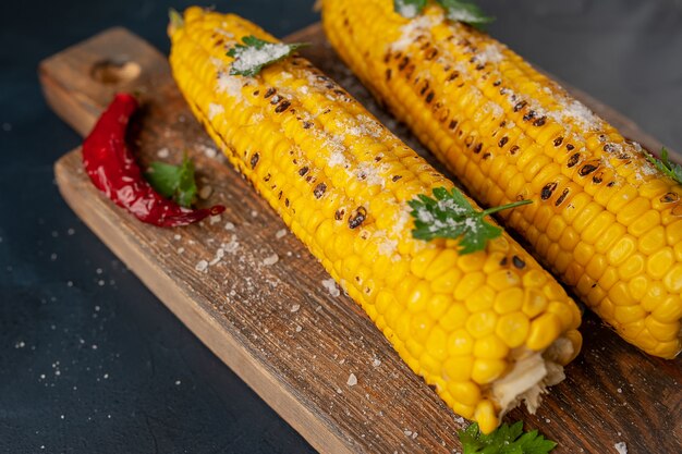 Milho grelhado com verduras e sal no fundo de concreto, lanche ou jantar, café da manhã