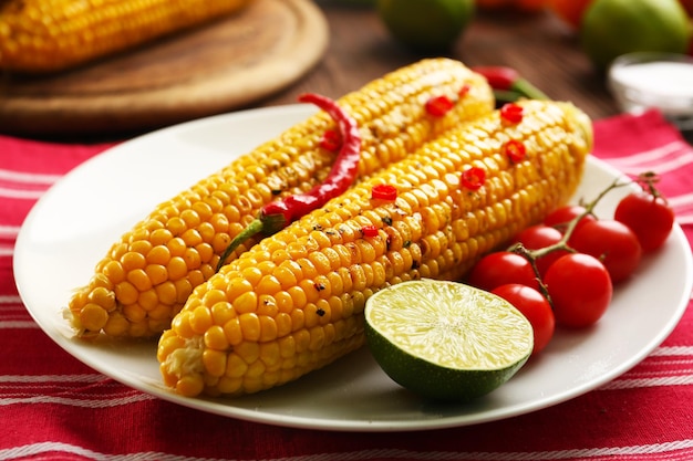 Milho grelhado servido com tomate e limão