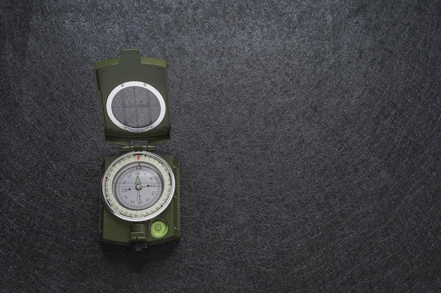 Foto militärgrüner kompass auf strukturiertem schwarzem hintergrund